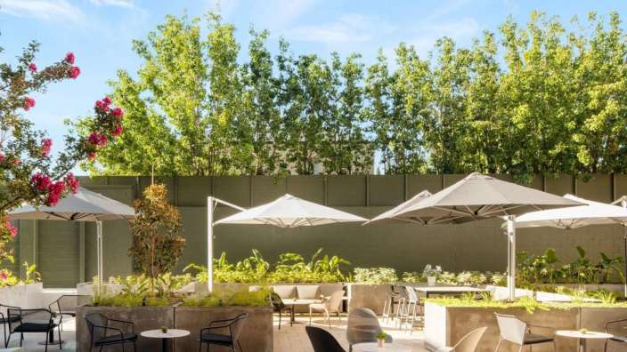 Eine Terrasse mit Tischen und Stühlen und Regenschirmen