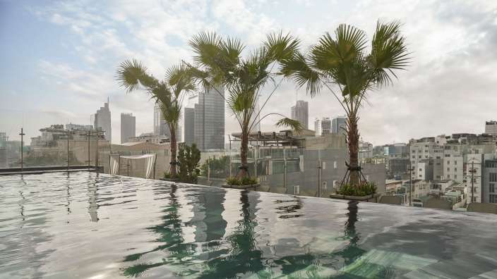 Ein Pool mit Palmen und Gebäuden im Hintergrund