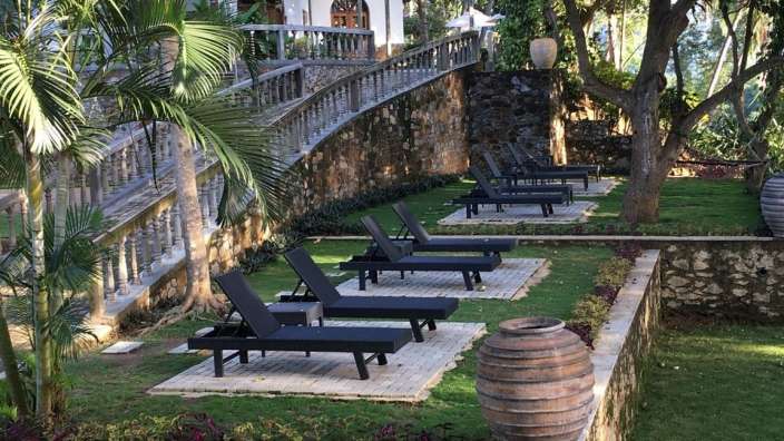 Eine Reihe von schwarzen Liegestühlen auf einem grünen Rasen