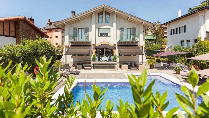 Ein großes weißes Haus mit einem großen Swimmingpool davor