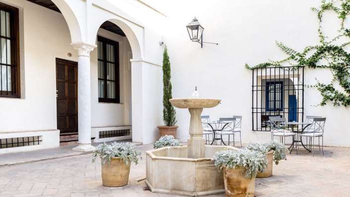 Ein weißes Gebäude mit einem Brunnen in der Mitte