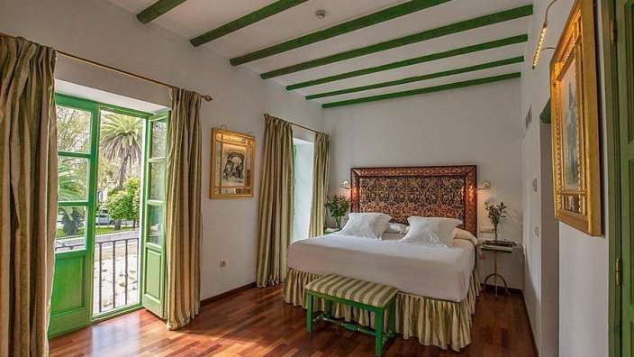 Ein Schlafzimmer mit einem Bett und grünen Vorhängen