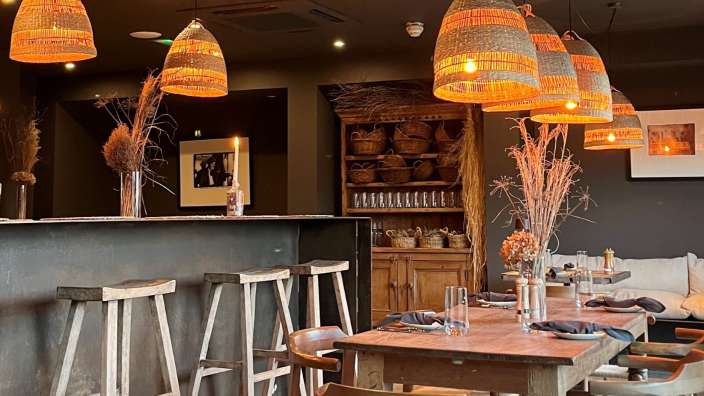 Ein Restaurant mit einem Tisch und Stühlen und vielen Lampen