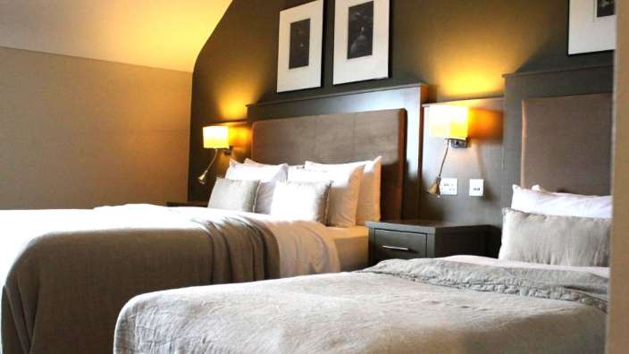Ein Hotelzimmer mit zwei Betten und zwei Bildern an der Wand