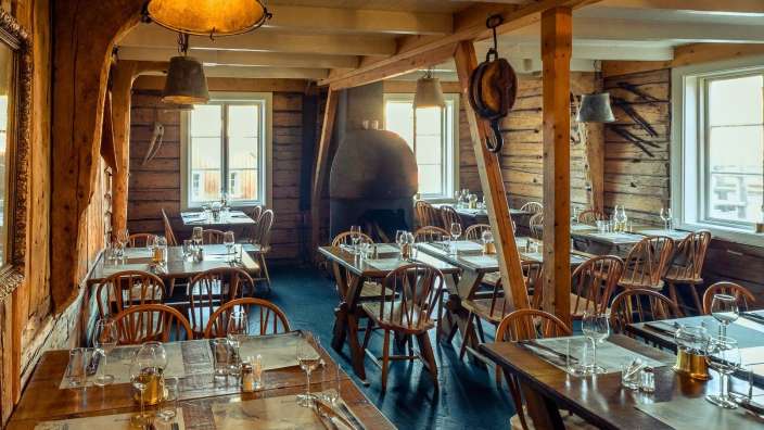 Ein Esszimmer mit vielen Holztischen und Stühlen