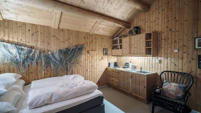 Ein Schlafzimmer mit einem Bett und einer kleinen Küche