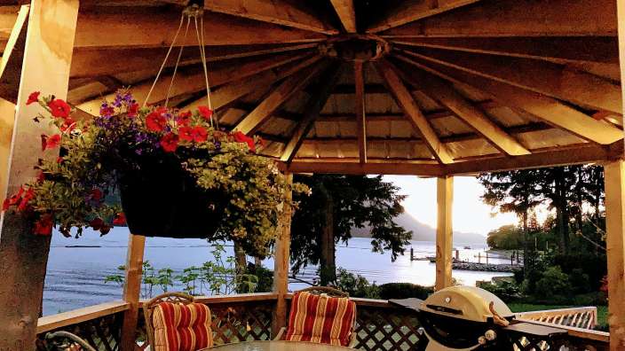 Ein Tisch und Stühle unter einem Holzpavillon mit Blick auf den Ozean