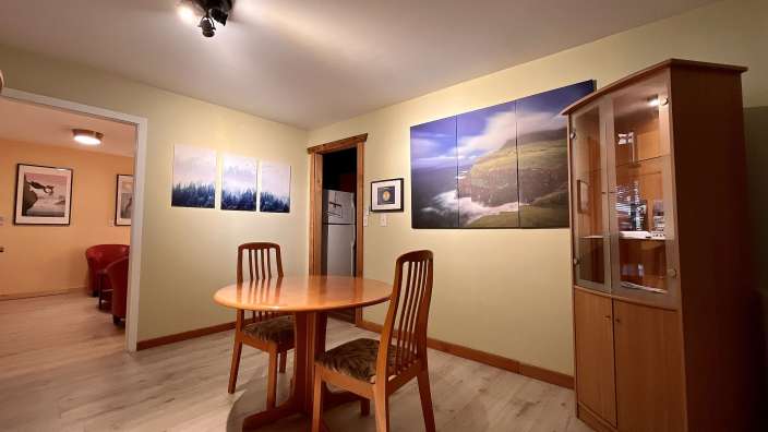 Ein Esszimmer mit einem Tisch und Stühlen und Bildern an den Wänden