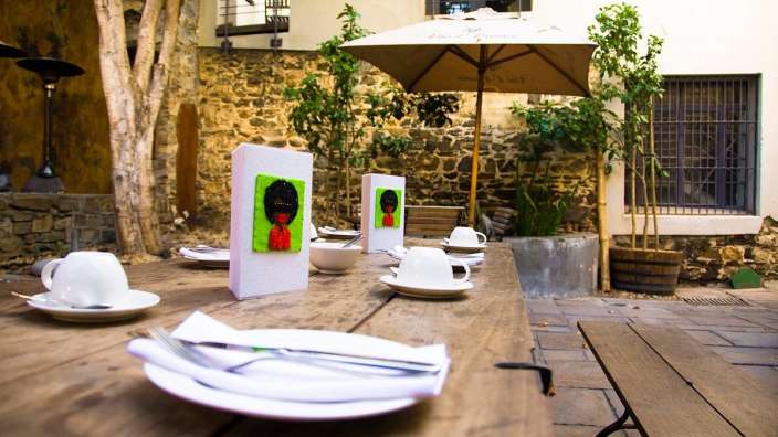 Ein holztisch mit tellern und tassen darauf und einem schirm mit der schrift ' a ' darauf