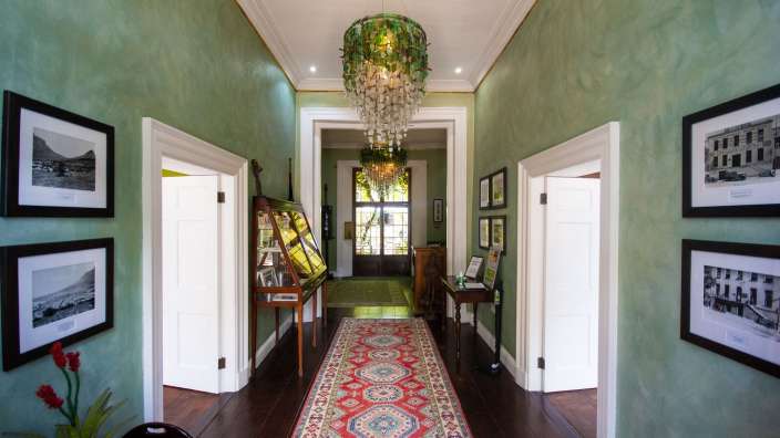 Ein Flur mit grünen Wänden und einem roten Teppich