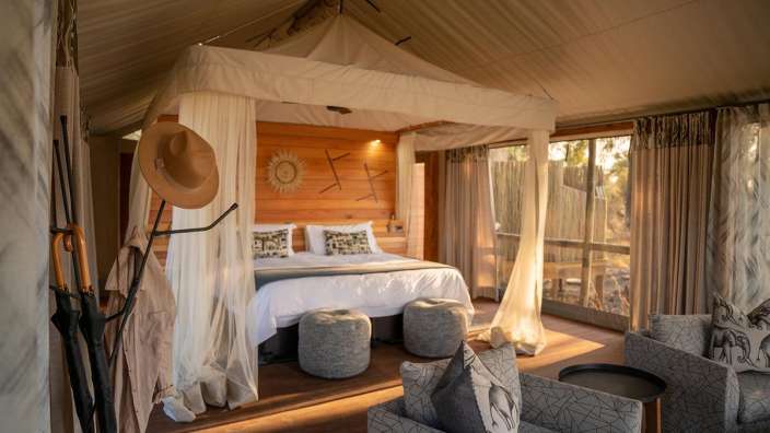 Ein Schlafzimmer mit Himmelbett und Stuhl