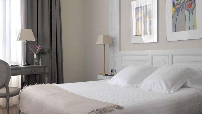 Ein Schlafzimmer mit einem Bett und zwei Bildern an der Wand