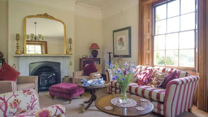 Ein Wohnzimmer mit gestreiften Möbeln und einem Kamin