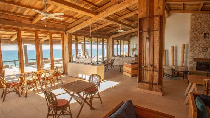 Ein Wohnzimmer mit Tisch und Stühlen und einem Segelschiff darauf