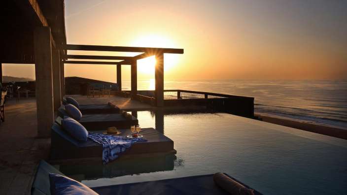 Ein Infinity-Pool mit Blick auf den Ozean bei Sonnenuntergang
