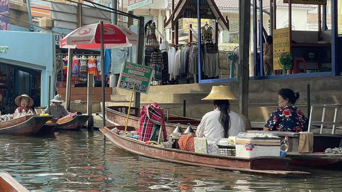 Eine Frau sitzt in einem Boot in einem Wassermarkt