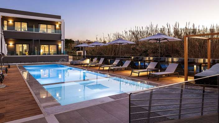 Ein großer Pool mit Liegestühlen und Sonnenschirmen umgeben