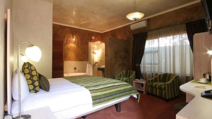 Ein Hotelzimmer mit einem Bett und zwei Stühlen