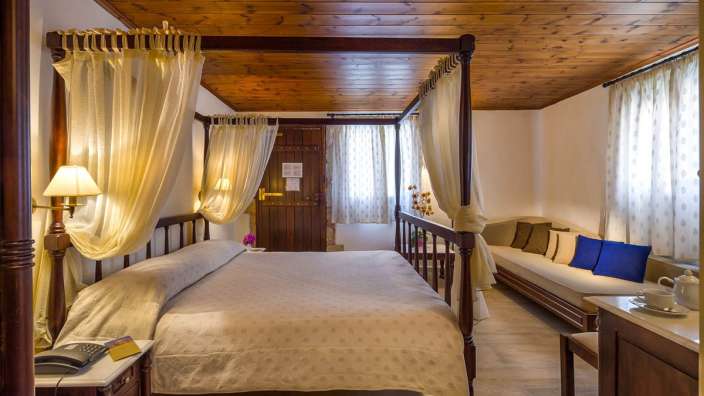 Ein Schlafzimmer mit einem Himmelbett und einem Couchtisch