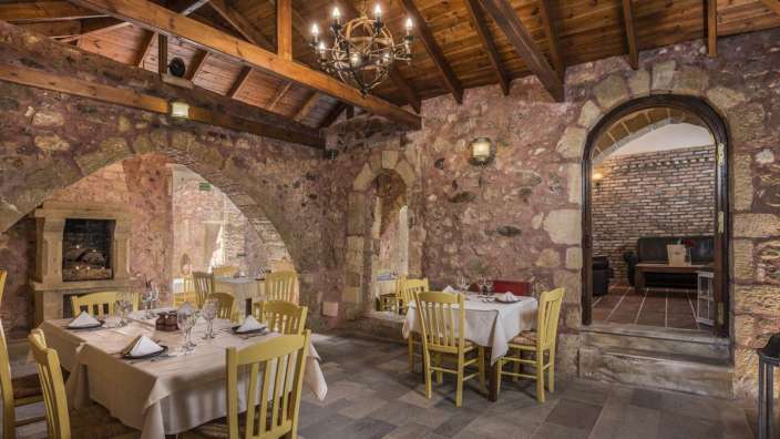 Ein Speisesaal mit Tisch und Stühlen und einem Kronleuchter