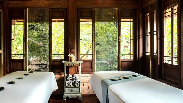 Zwei massagetische in einem raum mit vielen fenstern