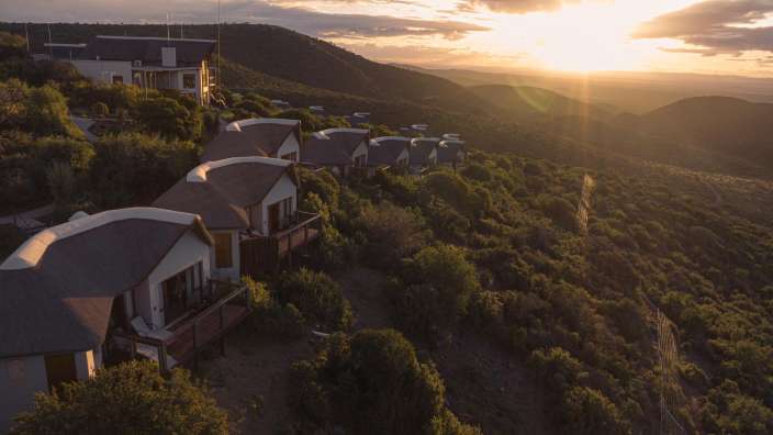 Eine Gruppe von Häusern auf einem Hügel bei Sonnenuntergang