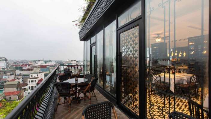 Tische und Stühle auf einem Balkon mit Blick auf die Stadt