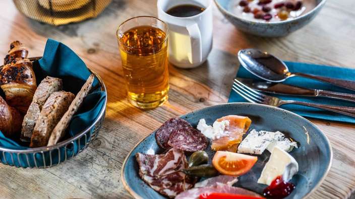 Auf einem holztisch steht ein teller mit fleisch und käse