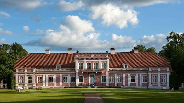 Ein großes rosa und weißes Gebäude mit einem roten Dach