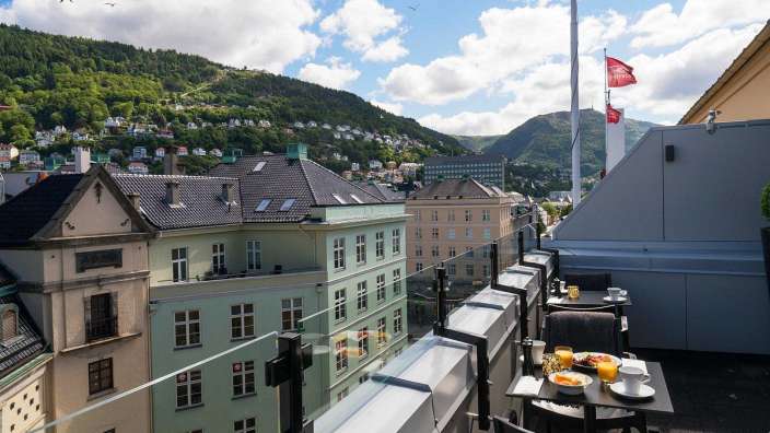 Ein Balkon mit einem Tisch und Stühlen und einer Flagge