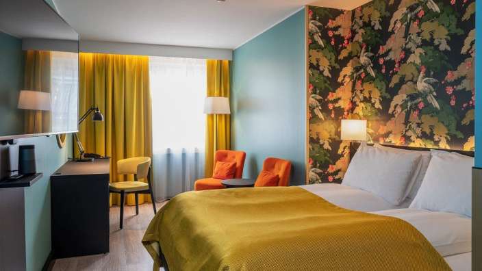 Ein Hotelzimmer mit einem Bett und zwei Stühlen