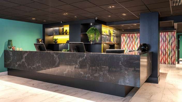 Ein schwarzer Schreibtisch mit zwei Computern in einem Hotel