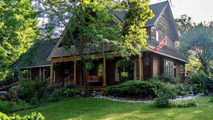 Ein braunes Haus mit einer roten Fahne davor