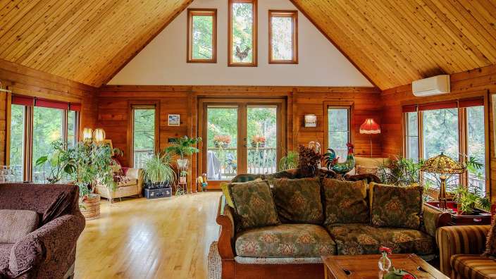 Ein Wohnzimmer mit vielen Fenstern und einer Couch