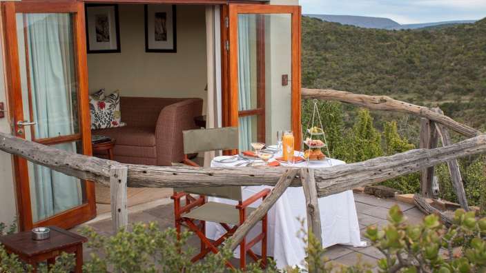 Eine Terrasse mit einem Tisch und Stühlen vor einem Haus