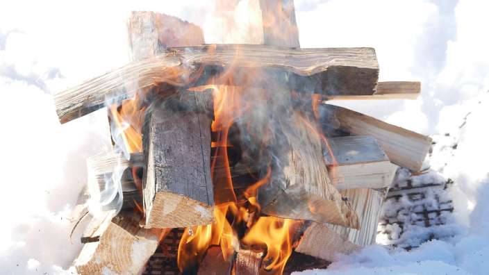 Ein Haufen Holz brennt im Schnee