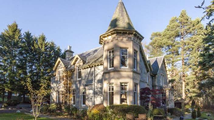 Ein großes Haus mit einem Turm und vielen Fenstern