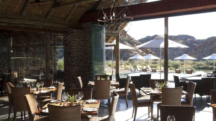 Ein Restaurant mit vielen Tischen und Stühlen mit Blick auf einen Pool