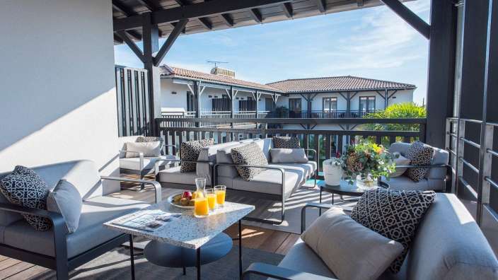 Ein Wohnzimmer mit einer Couch, zwei Stühlen und einem Tisch