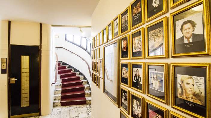 Ein Flur mit vielen Bildern an der Wand und einer Treppe