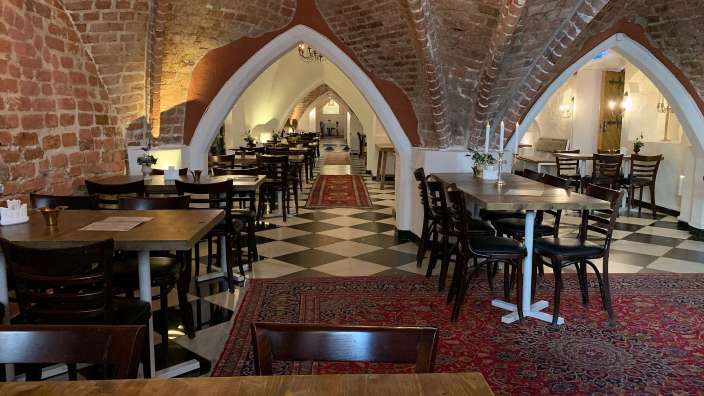 Ein Restaurant mit Tisch und Stühlen und einem karierten Teppich