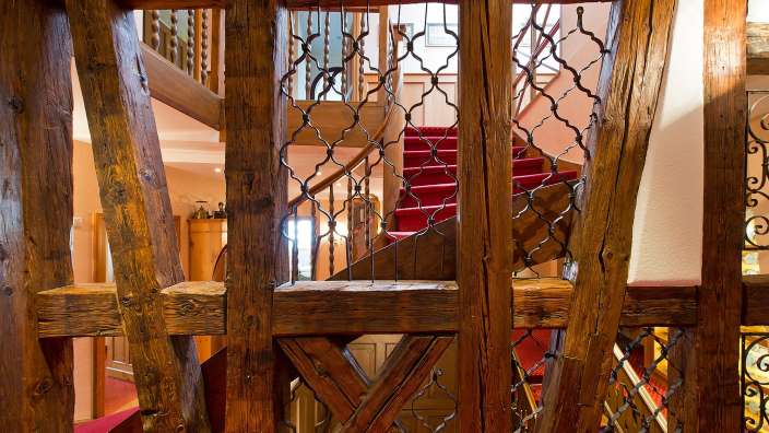 Eine Treppe mit einem roten Teppich und einem Holzgeländer