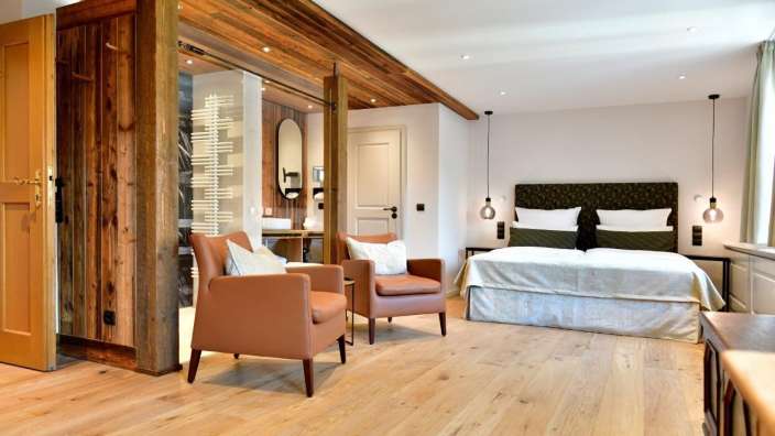 Ein Hotelzimmer mit einem Bett und zwei Stühlen