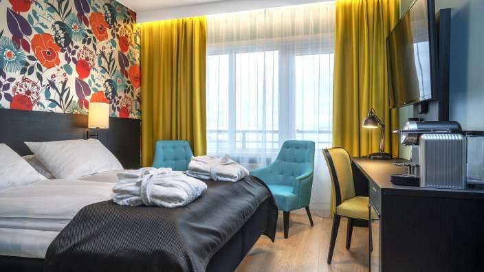 Ein Hotelzimmer mit einem Bett und zwei Stühlen