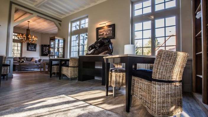 Ein Wohnzimmer mit Tisch und Stühlen und vielen Fenstern