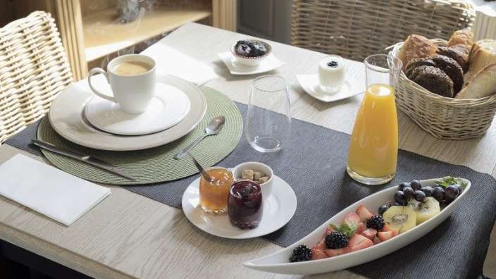 Ein tisch mit einem teller mit früchten und einer tasse kaffee