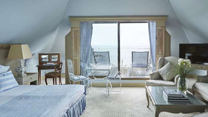 Ein Schlafzimmer mit einem Bett, einem Stuhl, einem Tisch und einem Fernseher