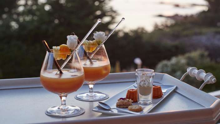 Ein Tablett mit zwei Cocktails und Desserts darauf