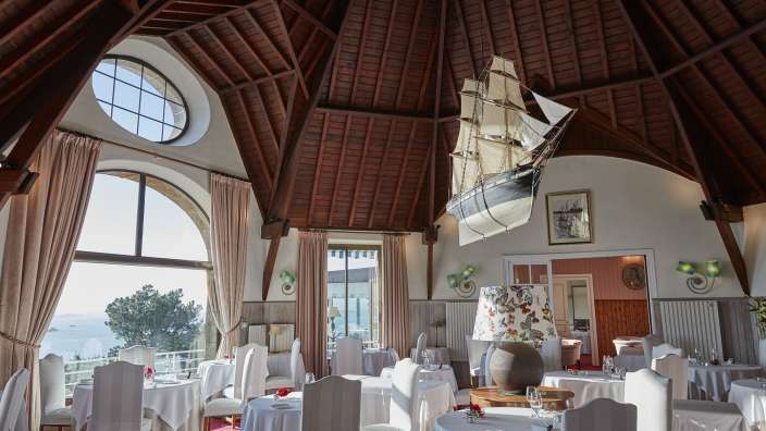 Ein riesiges Segelschiff hängt an der Decke eines Restaurants