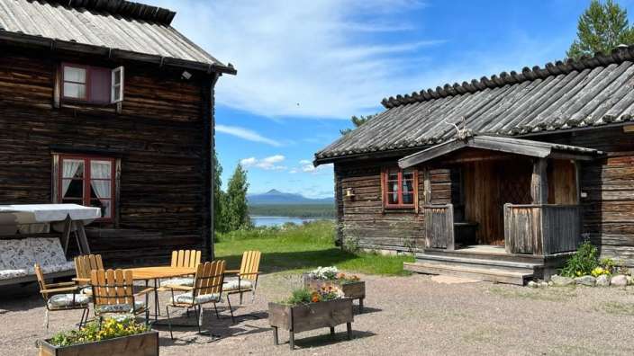 Ein Holzhaus mit einem Tisch und Stühlen davor